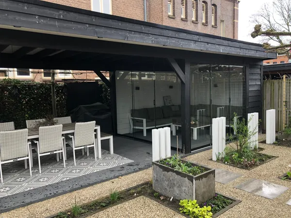 Tuinpad met grindbed en grote stapstenen tussen plantenbakken.