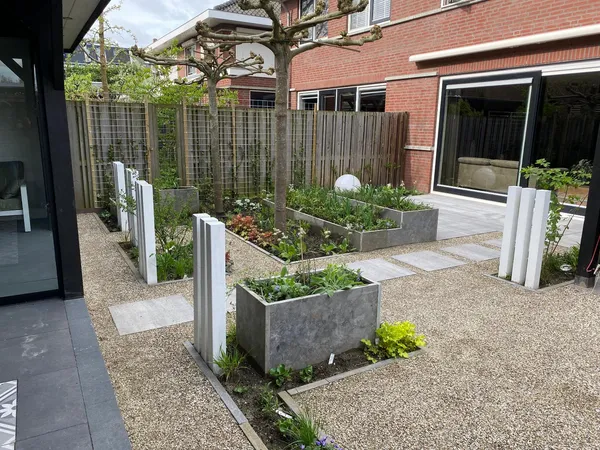 Oprit met grijs grindbestrating voor garage en woning.