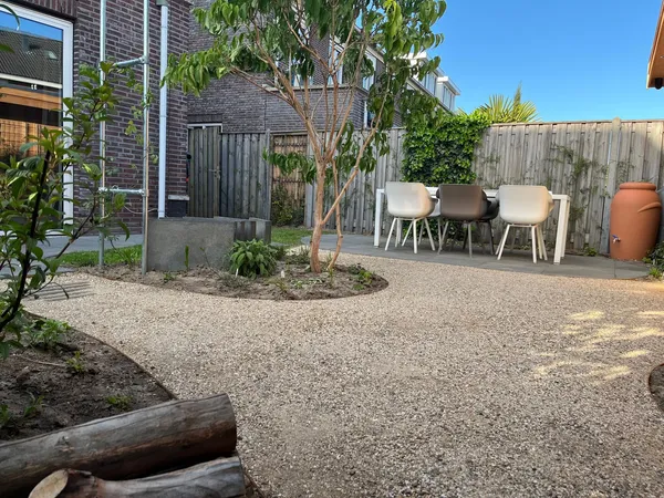 Houten tuinkamer met grindterras en grijze tegelbestrating.
