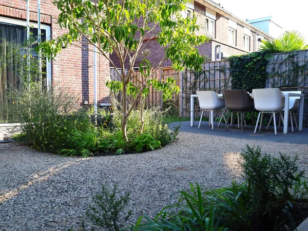 Voortuin met natuurstenen keermuur en klinkerbestrating.