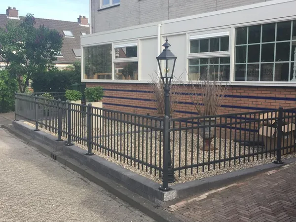 Terras met flagstones uit natuursteen tussen witte plantenbakken.