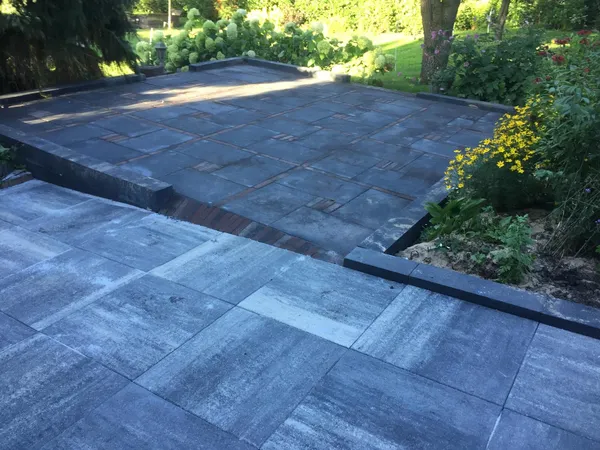 Modern terras met grijze tegelbestrating en accent van klinkers.