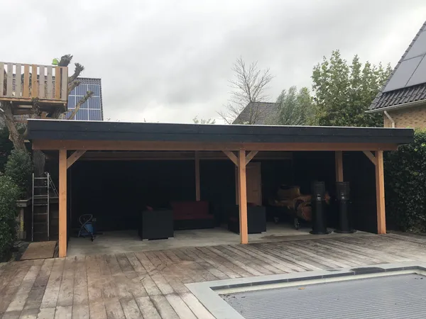 Grote houten overkapping met loungeset en vlonder naast zwembad.