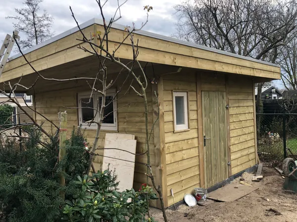 Houten schuur met zadeldak en cederhouten gevel.
