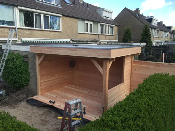 Nieuwbouw van houten overkapping met cederhouten wanden in achtertuin.