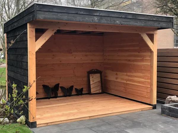 Moderne zwarte overkapping met cederhouten binnenzijde en plat dak.
