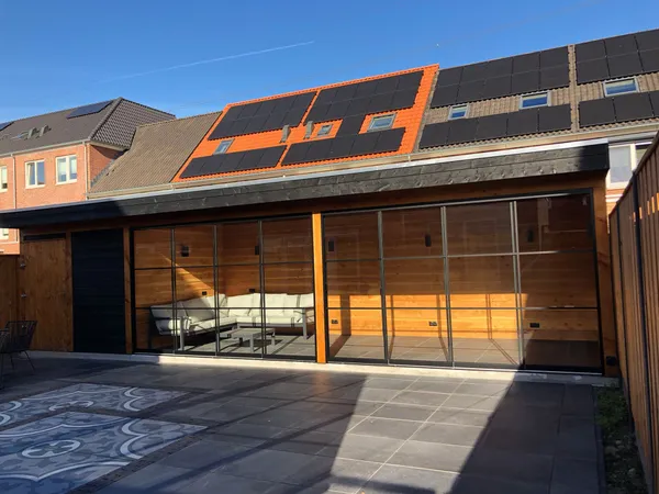 Gesloten houten overkapping met glazen wanden en tegelbestrating.